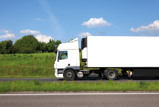 lång lastbil med vit lastbil och trailer på motorvägen mot blå himmel. - Fotografie, Obrázek