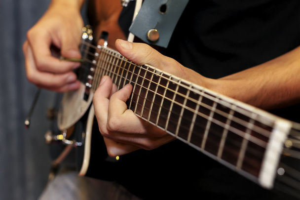 ηλεκτρική κιθάρα γκρο πλαν με τα δάχτυλα που παίζουν αυτό - Φωτογραφία, εικόνα
