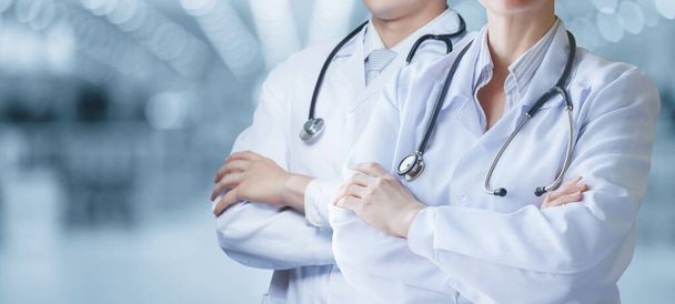 Artsen staan met hun armen gekruist tegen een wazige achtergrond. - Foto, afbeelding