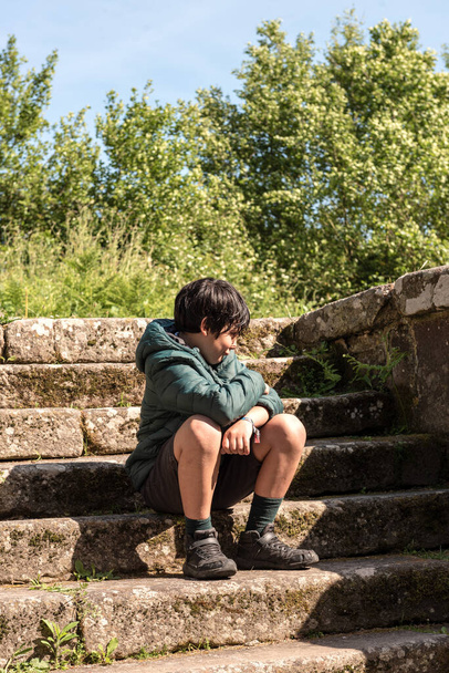 Kleiner Junge sitzt auf einer Steintreppe - Foto, Bild