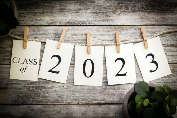 A set of printed cards spelling the word 2023 on an aged wooden background. - Photo, Image