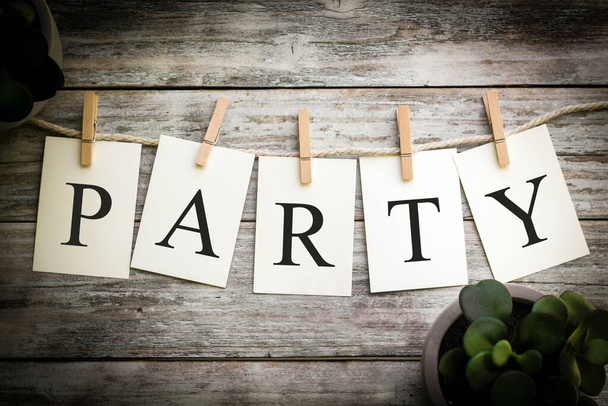 A set of printed cards spelling the word PARTY on an aged wooden background. - Photo, Image