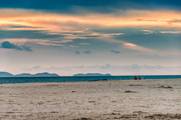 Statki pływają w oceanie jako nierozpoznawalni turyści plażowi cieszą się czasem spędzonym na plaży Jomtien w Pattaya Tajlandia. - Zdjęcie, obraz