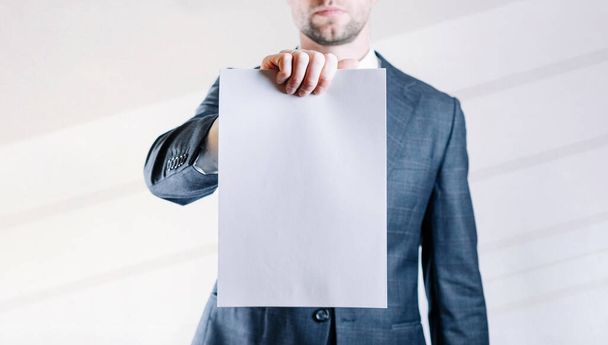 Businessman blank card. White blank board template holding business man on white background. Copy space empty poster - Photo, image