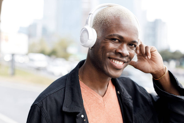 man with black skin listening to the music with headphones outdoor - Zdjęcie, obraz