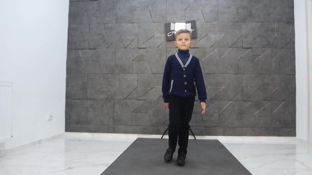 Malý chlapec model na lávce, krásné dítě pózující pro kameru - Záběry, video