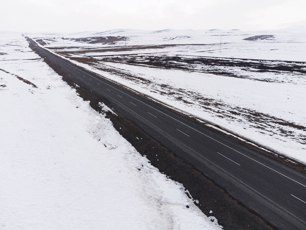 Aerial diagonal view of a road with one lane and snow in winter. - Foto, Imagem