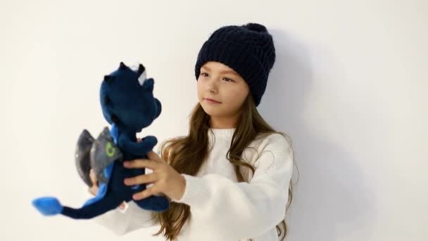 Bebé adolescente con un juguete suave sobre un fondo blanco - Metraje, vídeo