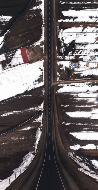 Aerial diagonal view of a road with one lane and snow in winter. - Fotografie, Obrázek