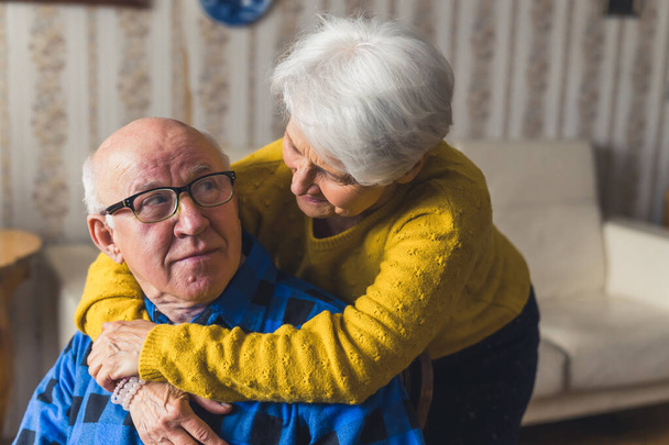 positive Cuacasian grandparents having fun and enjoying together at home medium closeup senior people support concept - 写真・画像