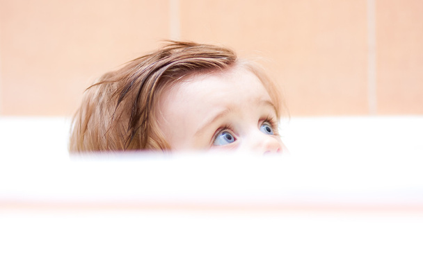 little cute baby peeking out of the bath. - Photo, Image
