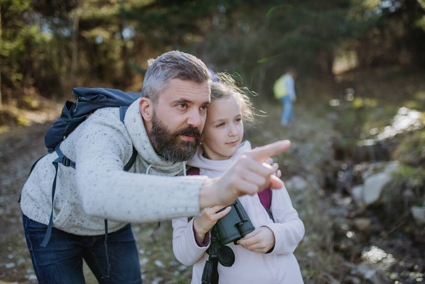 Father with small daughter with binoculars on walk in spring nature together. - Foto, Imagem