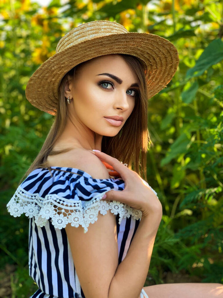 Beautiful young woman in a field of sunflowers - Foto, Imagem