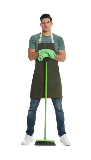 Man with green broom on white background - Foto, imagen