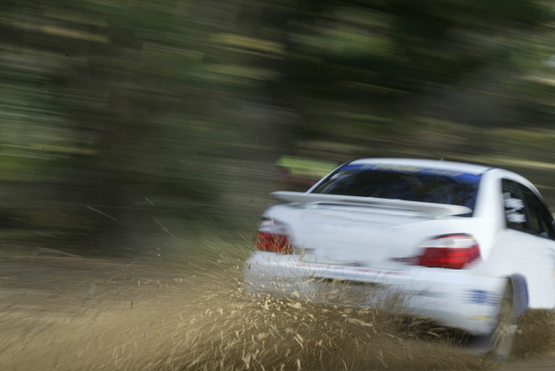 Белый гоночный автомобиль брызгает грязь
 - Фото, изображение