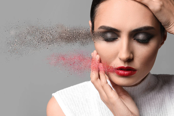 Young woman with beautiful makeup on grey background - Φωτογραφία, εικόνα