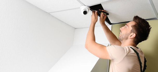 Technicus installeert smart home beveiligingssysteem in de kamer - Foto, afbeelding