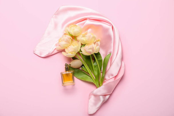 Μπουκέτο με όμορφες τουλίπες και μπουκάλι άρωμα σε ροζ φόντο - Φωτογραφία, εικόνα