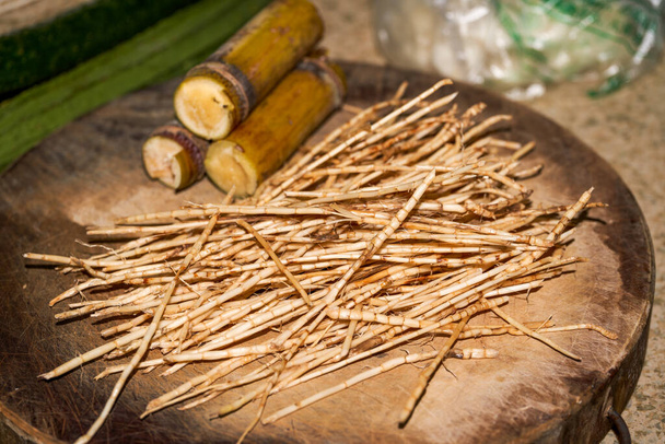 Una de las materias primas de raíz de estrangulamiento, bambú y agua de caña de azúcar para el té de hierbas tradicional de Guangdong, primer plano de raíz de estrangulamiento - Foto, imagen