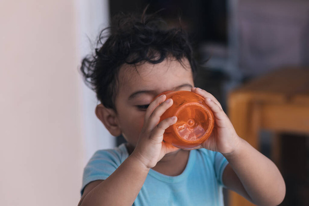 juoda vettä oranssissa lasissa talon ulkopuolella - Valokuva, kuva