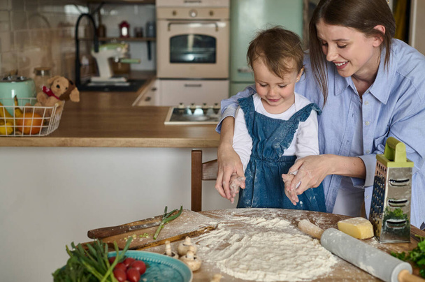 dad mom and their daughter cook pizza together in the kitchen. The concept of a happy family - Foto, Imagen