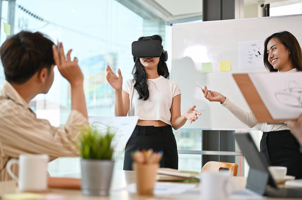 Azjatycka graficzka prezentująca swój projekt na spotkaniu, użytkowniczka testująca grę VR. Innowacje w wirtualnej rzeczywistości.  - Zdjęcie, obraz