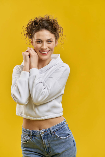 Pretty girl with curly hair posing, smiling. - Фото, зображення