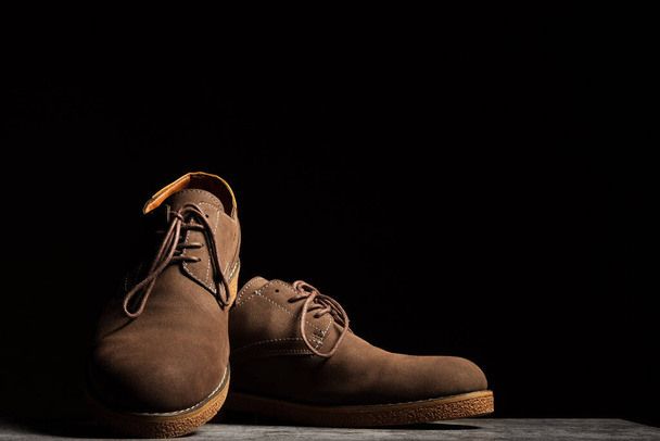 Элегантные коричневые туфли со шнурками на черном фоне с копировальным пространством. - Фото, изображение