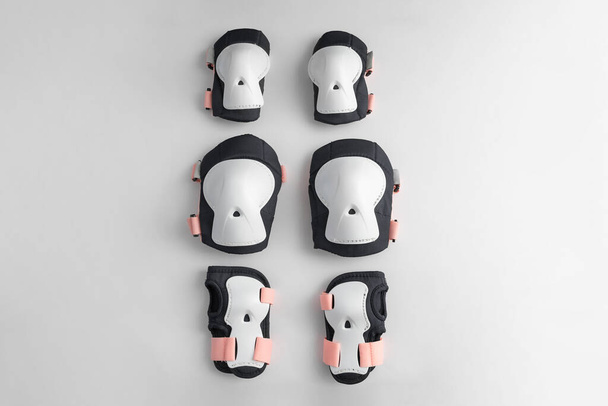 Top view of roller skates protective gear set - knee, elbow and wrist pads in pink colors. White grey background flat lay  - Φωτογραφία, εικόνα