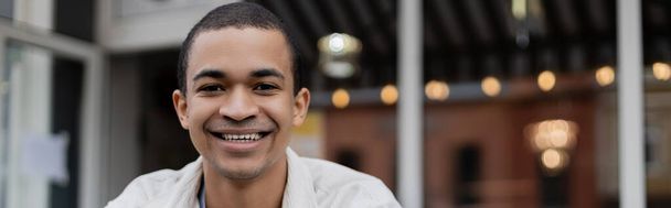 smiling and young african american man looking at camera outside, banner - Foto, Imagem