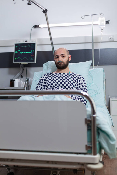 Depressziós férfi krónikus bronchitisben, amelyet sóoldattal kezelnek az iv. infúziós szerelékből történő folyadékpótlás miatt - Fotó, kép