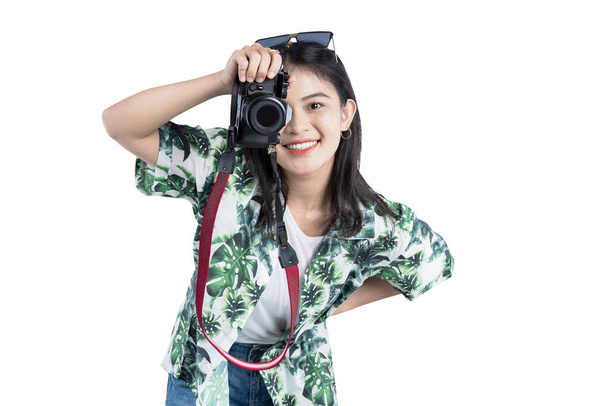 Asian woman with sunglasses using her camera standing isolated over white background - Fotó, kép