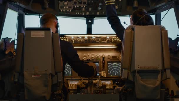 Kapitan samolotu i kobieta drugi pilot ustalający wysokość na desce rozdzielczej - Materiał filmowy, wideo