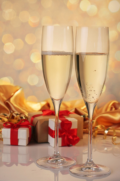 Copas de champán con regalos de cinta roja
 - Foto, Imagen