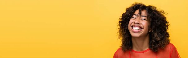happy african american woman with closed eyes smiling isolated on yellow, banner - Foto, immagini