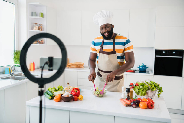 Foto veselý pohledný chlap streamer demonstrovat salát ingredience mix mísa kuchyně uvnitř - Fotografie, Obrázek