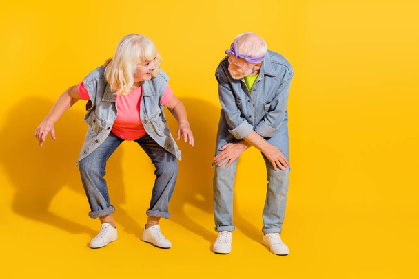Photo of charming funky girlfriend boyfriend dressed denim outfit having fun empty space isolated yellow color background - Φωτογραφία, εικόνα