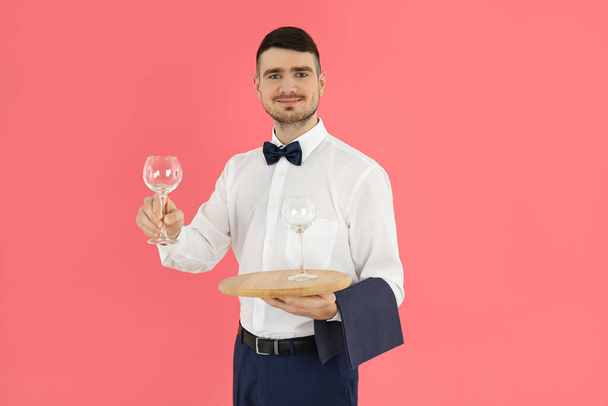 Concept of occupation, young waiter on pink background - Foto, Bild