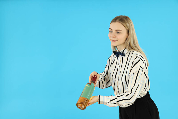 Concept of occupation, young female waiter on blue background - 写真・画像