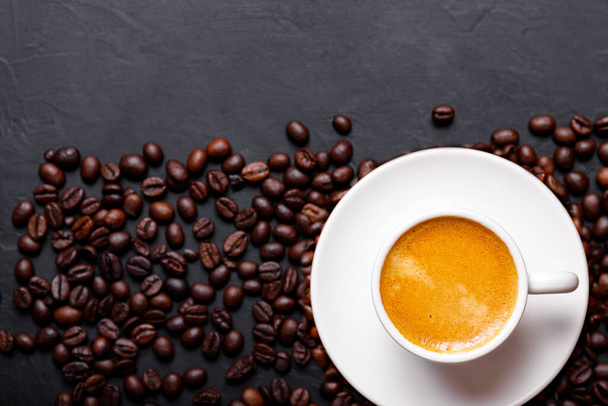 Café preto fresco quente com espuma de leite para menu da manhã em xícara de cerâmica branca com grãos de café assados - Foto, Imagem