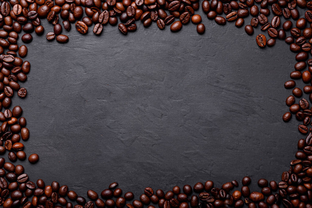 Warmer schwarzer Kaffee mit Milchschaum für das Morgenmenü in weißer Keramiktasse mit gerösteten Kaffeebohnen - Foto, Bild
