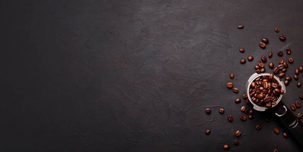 Horizontal banner with cup of coffee and coffee beans on dark stone background. Top view. Copy space - Foto, afbeelding