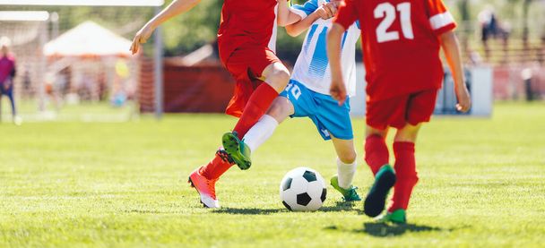 Nuoret pojat kilpailevat Tournament Match kaksintaistelussa. Jalkapallo peli kesällä aurinkoinen päivä. Koululaiset punainen ja sininen Jersey univormut käynnissä klassinen jalkapallo pallo pallo ruoho Pitch - Valokuva, kuva