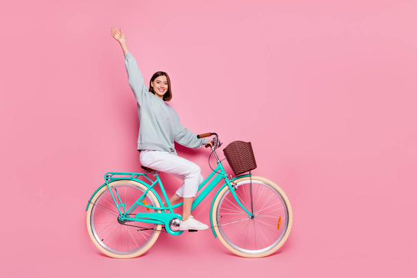 Full size profile side photo of young girl wave hi ride bicycle weekend isolated over pink color background - Fotografie, Obrázek