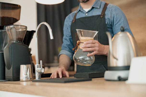 barista sostiene en sus manos un recipiente de vidrio para hacer café de filtro - Foto, Imagen