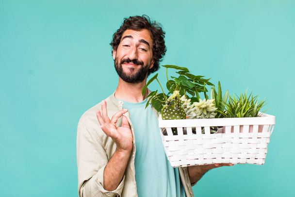 young adult hispanic crazy man with plants. gardering concept - Photo, Image