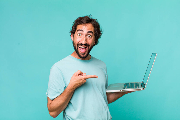 young adult hispanic crazy man with a laptop - Fotoğraf, Görsel