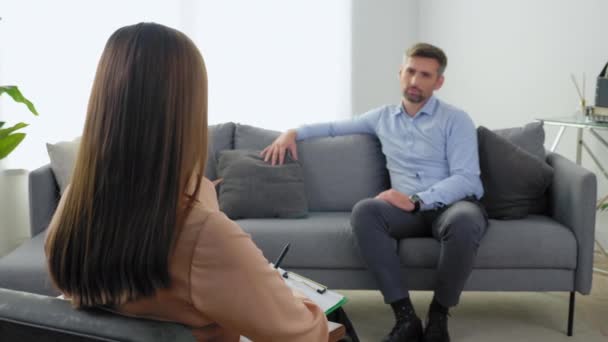 Γυναίκα ψυχολόγος με πρόχειρο μιλάει με ασθενή σε συνεδρία ψυχοθεραπείας - Πλάνα, βίντεο