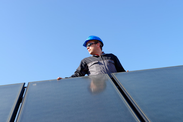 άνθρωπος την εγκατάσταση ηλιακοί συλλέκτες - Φωτογραφία, εικόνα