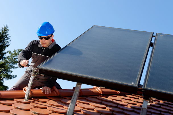 Homme installant des panneaux solaires
 - Photo, image